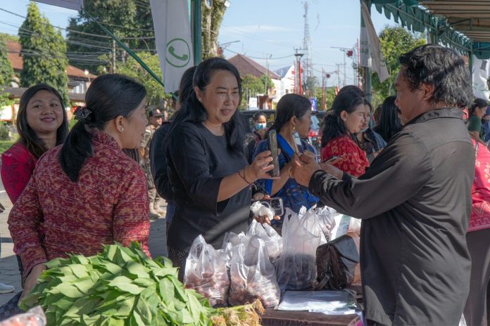 Ketua TP PKK Kabupaten Bangli, Ny. Sariasih Sedana Arta saat bertransaksi di salah satu UMKM dalam Pasar Tani