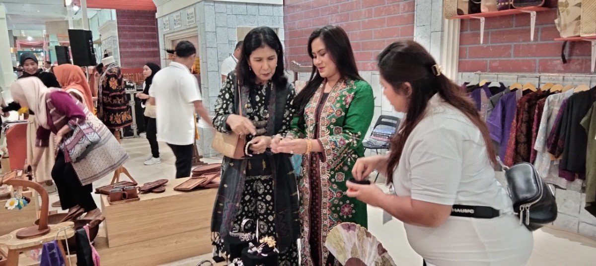Luh Ade Wijayanthi Perwakilan Pengelola Rumah BUMN denpasar (kanan) memberikan penjelasan terkait produk yang dipamerkan kepada Sita Evi Hariady (kiri), Diny Darmawan Prasodjo (tengah).