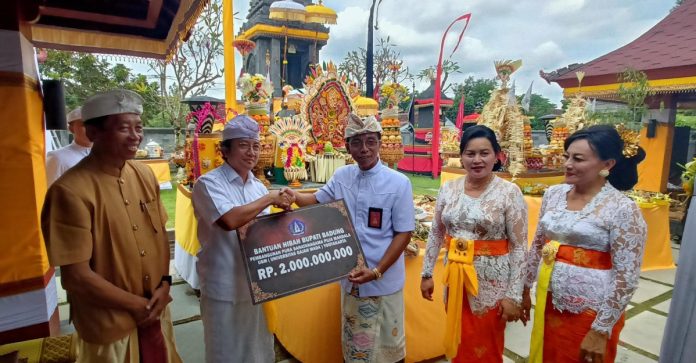 Kepala Dinas Kebudayaan Badung, I Gde Sudarwitha didampingi Ketua TP. PKK Badung Nyonya Seniasih Giri Prasta menyerahkan dana hibah di Pura Sanatanagama, Universitas Gadjah Mada, Yogyakarta, Selasa 23 April 2024.