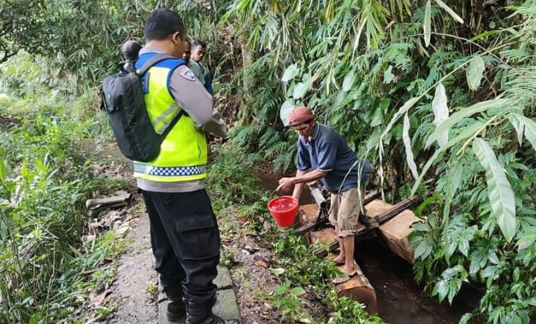 Polisi saat melakukan olah TKP di lokasi kejadian buruh angkut kayu yang meregang nyawa usai terjatuh di saluran irigasi.