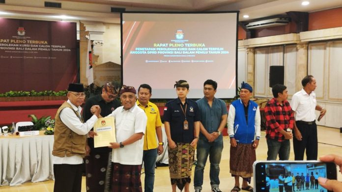 Ketua KPU Bali I Dewa Agung Gede Lidartawan saat menyerahkan SK penetapan anggota Dewan Perwakilan Rakyat Daerah (DPRD) Provinsi Bali periode 2024-2029.