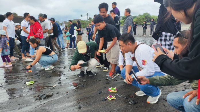 Komunitas dan Manajemen Astra Motor Bali saat pelepasan tukik di pantai Yeh Gangga pada Minggu, 9 Juni 2024.