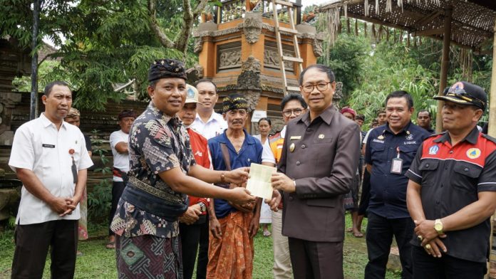 Wabup Ketut Suiasa menyerahkan bantuan fisik bangunan pascabencana di Kecamatan Petang dan Kecamatan Abiansemal, Rabu (24/7).