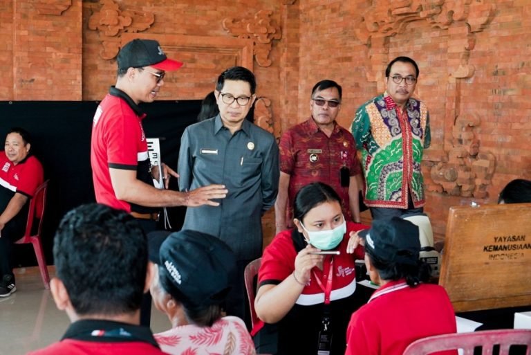 Sekda Wayan Adi Arnawa saat memantau pelaksanaan pemeriksaan katarak dan operasi katarak yang diselenggarakan oleh John Fawcett Foundation yang bekerjasama dengan KKN UGM, di Wantilan Pura Dalem Desa Adat Baha, Selasa 16 Juli 2024.