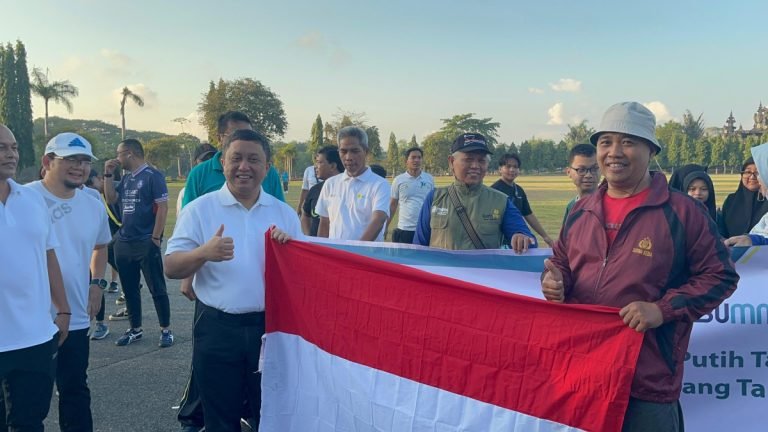 Plh General manager PT PLN (Persero) UID Bali Rizky Mochamad membuka bendera yang diberikan kepada salah satu warga.