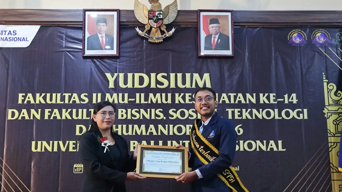 Dekan Ni Made Sintya Noviana Utami, S.Psi. saat menyerahkan sertifikat lulusan terbaik dengan predikat cumlaude kepada I Wayan Arya Wahyu Mahardika, S.Psi dalam yudisium ke-6 Fakultas Bisnis, Sosial, Teknologi, dan Humaniora (FBSTH)