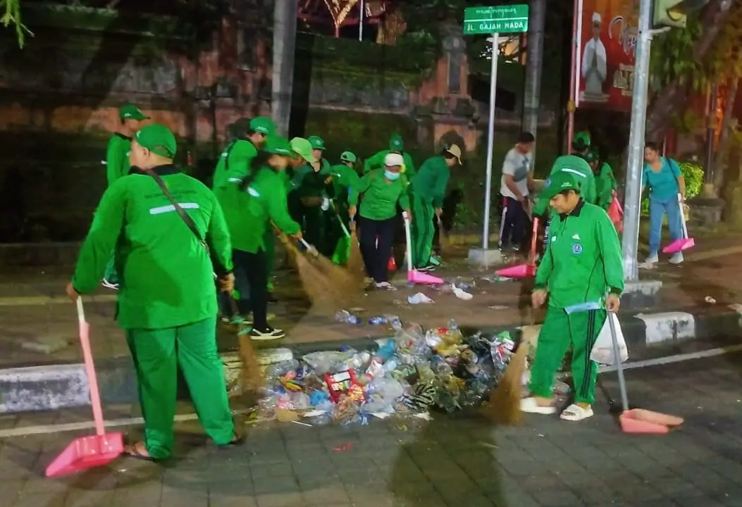 Tenaga Kebersihan DLHK Kota Denpasar saat bertugas usai Pengarakan Ogoh-ogoh Malam Pangerupukan serangkaian Nyepi Caka 1947 di Kota Denpasar, Jumat (27/3) dini hari.