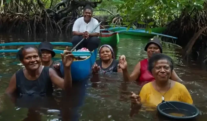 Aktivitas perempuan Enggros di Hutan Perempuan, hutan mangrove adat yang pulih setelah penanaman lebih dari 8.000 bibit mangrove dan kegiatan bersih pantai yang menurunkan sampah hingga 30%. Pemulihan ini mengembalikan ketersediaan kerang dan kepiting sebagai sumber pangan dan pendapatan harian keluarga.