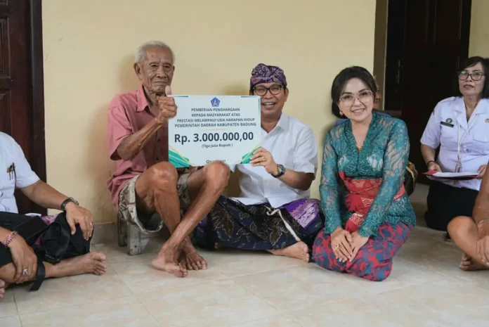 Bupati Wayan Adi Arnawa dan Ketua TP. PKK Badung Nyonya Rasniathi saat berikan penghargaan dan serahkan akta kelahiran kepada I Wayan Siteng (101 tahun), warga Banjar Suluban, Desa Pecatu, Kuta Selatan, Rabu (28/1).