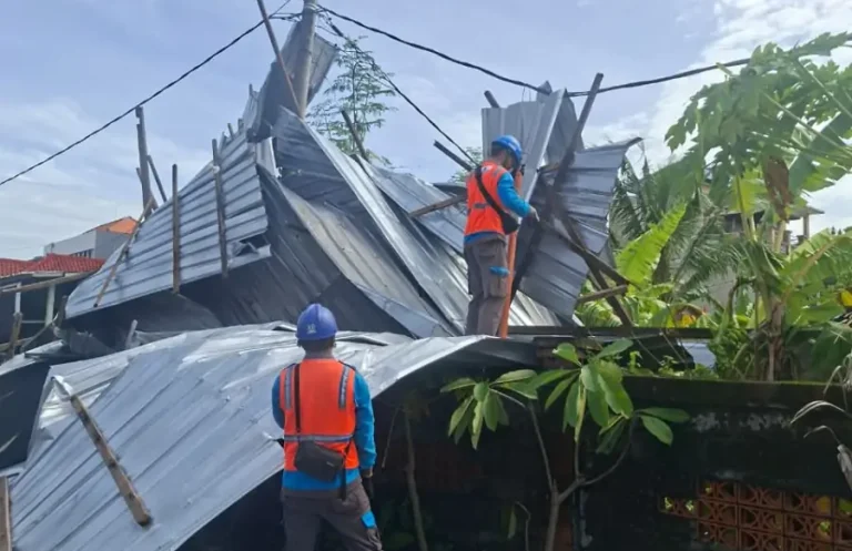 Petugas PLN melakukan pengamanan jaringan listrik pada rumah di kawasan sidakarya Denpasar yang terdampak angin puting beliung.