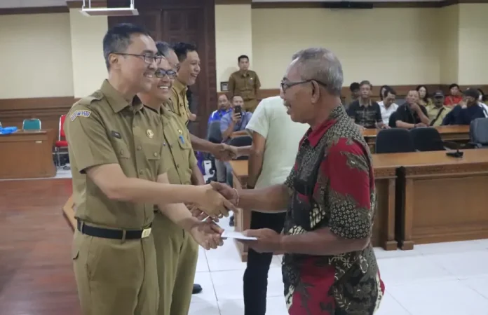 Sekretaris Daerah (Sekda) Kabupaten Badung sekaligus Ketua Dewan Pengurus KORPRI Kabupaten Badung, Ida Bagus Surya Suamba, menyerahkan santunan pensiun kepada 87 anggota KORPRI yang telah menyelesaikan masa pengabdiannya