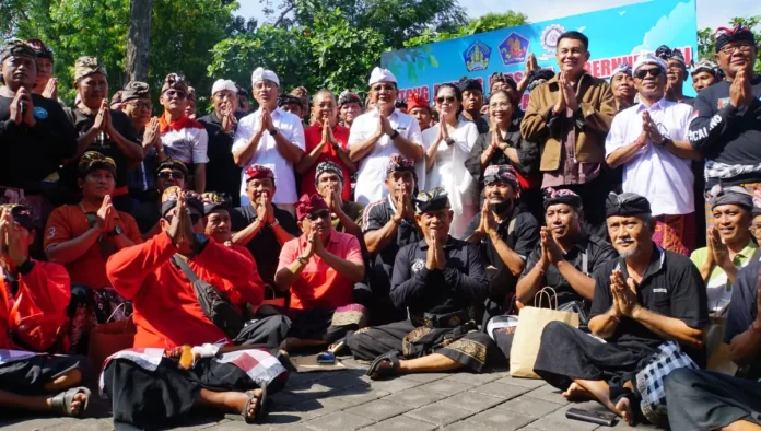 Bupati Buleleng I Nyoman Sutjidra mendampingi Gubernur Bali Wayan Koster menyerahkan set seragam kepada 503 pecalang di 14 banjar adat Desa Adat Buleleng untuk mendorong semangat pengamanan wilayah desa adat.