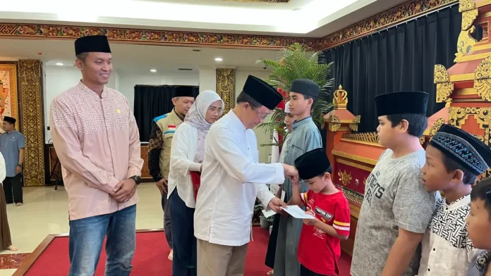Direktur Retail dan Niaga PT PLN (Persero) Adi Priyanto menyerahkan santunan kepada 20 anak-anak yatim dalam program berbagi kebahagiaan Ramadan YBM PLN di Kantor PLN UID Bali, Jumat (13/3).