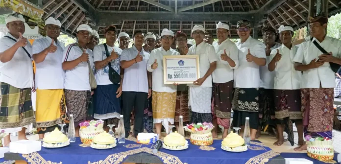Bupati Adi Arnawa saat menyerahkan bantuan pemulihan dampak bencana Pura Taman Beji Magendra, Desa Adat Tegal Darmasaba, Desa Darmasaba, Kecamatan Abiansemal, Rabu (22/4/2026).