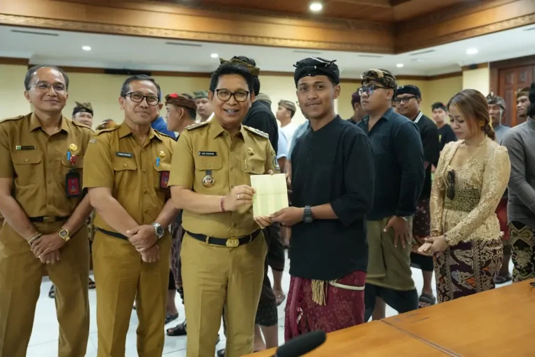 Bupati Adi Arnawa saat menyerahkan buku rekening tabungan kepada 26 Sekaa dan Komunitas Seni yang akan menjadi Duta Kabupaten Badung pada PKB XLVIII Tahun 2026, di Puspem Badung, Senin (13/4).