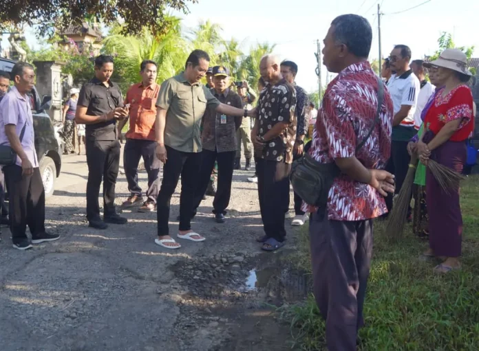 Bupati I Made Kembang Hartawan meninjau dua ruas jalan rusak di Desa Baluk dan memastikan pengerjaan hotmix segera dilakukan pada Juni untuk meningkatkan akses dan konektivitas masyarakat.